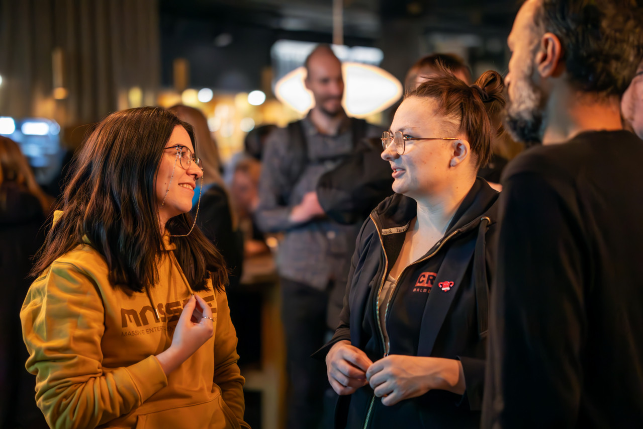 Three game developers talking at a meetup
